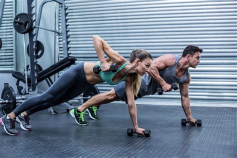 Muscular Couple Doing Plank Exercise While Lifting Weights Carvilles