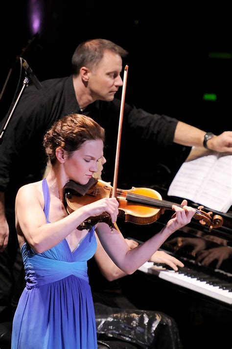 A Woman In A Blue Dress Playing The Violin With A Man In Black Shirt