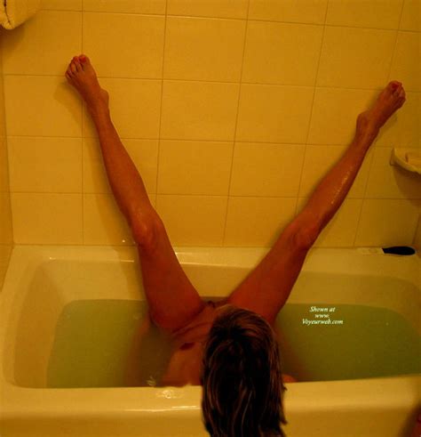 Brunette Naked In The Tub Sideways With Legs On Wall