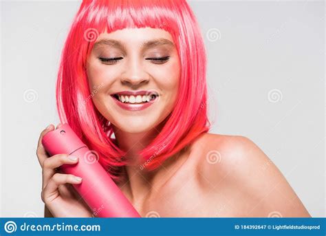 naked girl in pink wig holding hair spray isolated on grey stock image