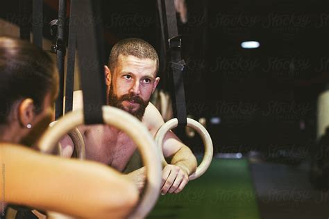 Couple Resting On Gymnastics Rings In A Gym By Stocksy Contributor