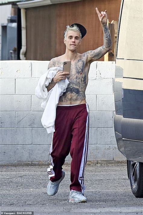 justin bieber puts his tattooed chest on display while