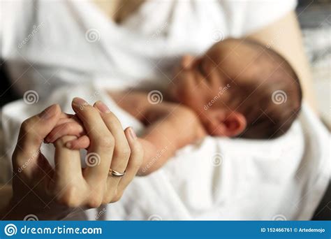 Little Hand Of A Newborn In A Large Hand Of Mother Stock