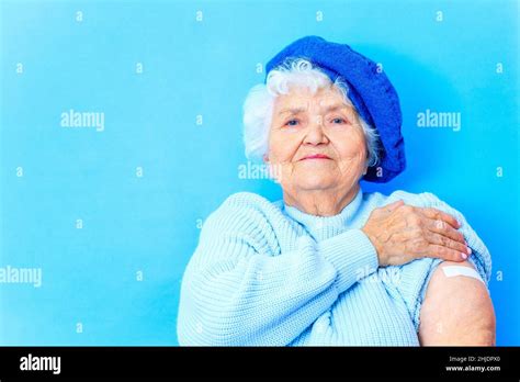 mature woman 80 years old showing her arm with bandage after receiving