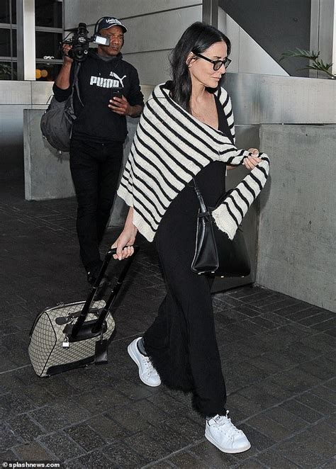 demi moore cuts a casual look in long black dress while arriving at airport in los angeles