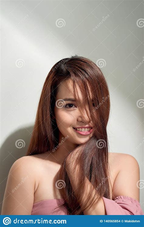 Romantic Long Haired Girl In Trendy Dress Posing With Shy Smile Indoor