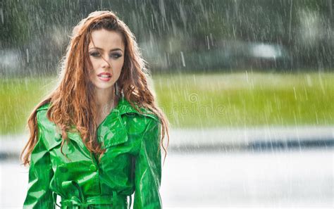 Beautiful Woman In Bright Green Coat Posing In The Rain Stock Image