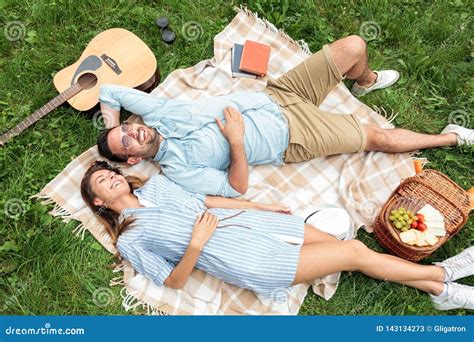 beautiful young couple lying      relaxing   picnic blanket enjoying