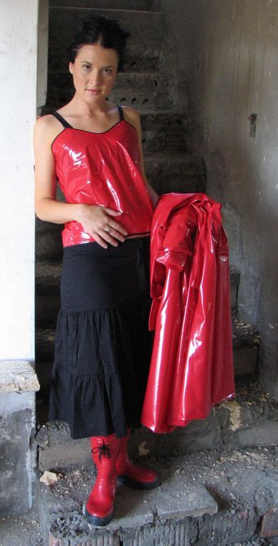 cute amateur brunette in broomstick skirt red pvc tank top raincoat and red wellies plaztic
