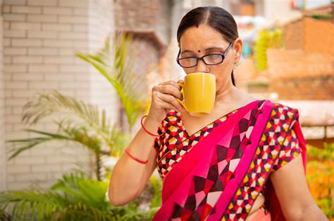 Beautiful Indian Mature Woman Drinking Coffee In The Fresh Air Stock