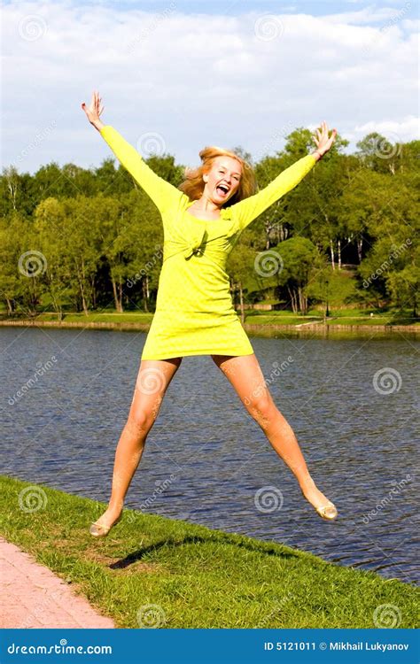 the happy girl jumps on the bank of the river stock image image of