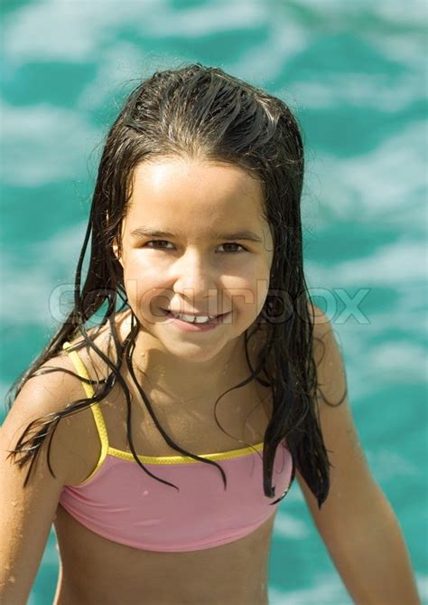 girl im badeanzug wasser im hintergrund porträt stock foto