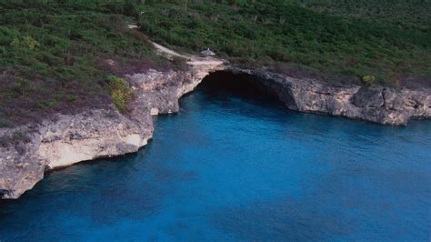 aerial view   blue water  cliffs  dusk   person standing   cave