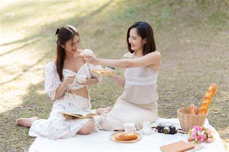 Beautiful Woman And Friend Having Picnic On Sunny Spring Day In Outdoor