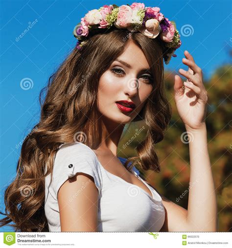 beautiful brunette with long curly hair in a wreath of