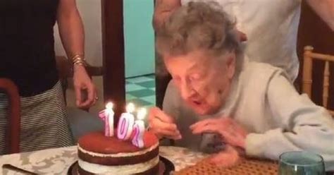 old lady blows tries to blow out the candles blows out her teeth