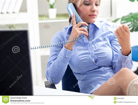 secretary sitting in office and talking on the phone