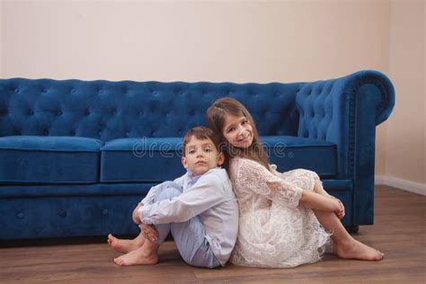 brother and sister sit on a blue sofa stock image image of beauty