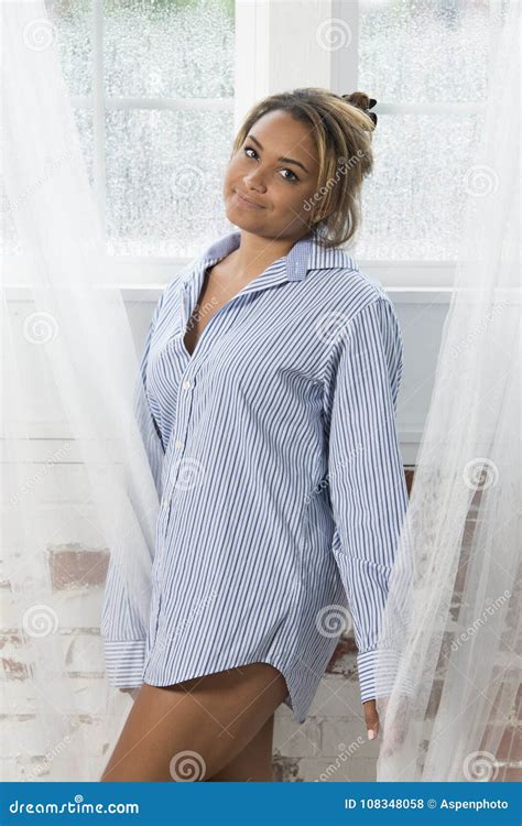 young woman lounges  white couch  mens shirt stock photo image