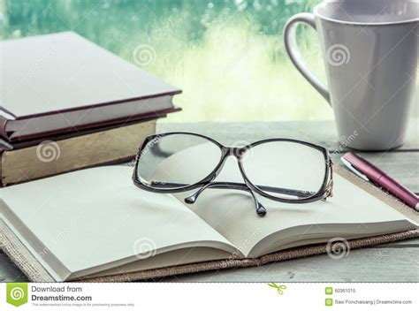 Eyeglasses On Open Notebook With Book Pen And Coffee Cup