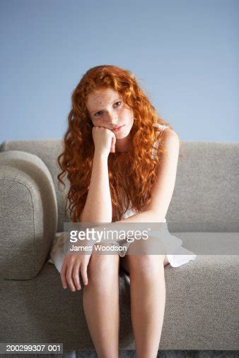 Teenage Girl Sitting On Sofas Edge Leaning On Hand Portrait Photo