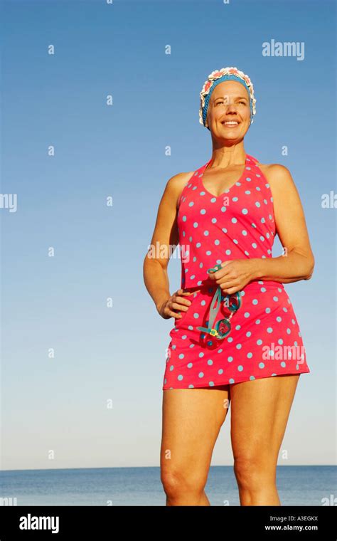 Low Angle View Of A Mature Woman Standing On The Beach And Smiling