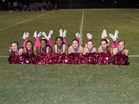 group  cheerleaders posing   photo   sidelines  night