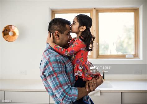 Daughter Kissing Father At Home Photo Getty Images