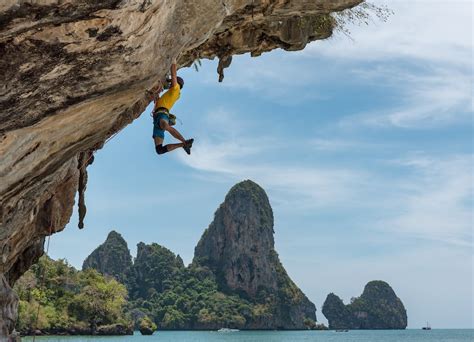 man climbing cliff  beach photo  sport image  unsplash
