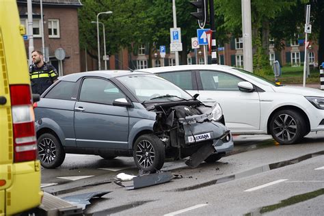 auto en brommobiel botsen tegen elkaar op kruising  tilburg bestuurders lichtgewond foto