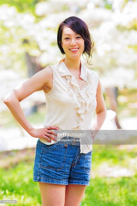 beautiful active healthy mature japanese woman in park portrait stock