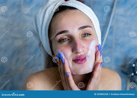 close up portrait of smiling brunette girl cleaning her cheeks with