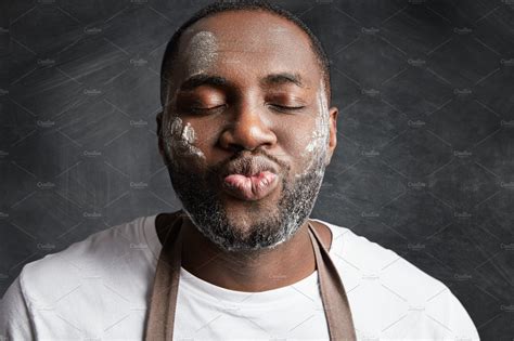 close up portrait of dark skinned male being satisfied after baking