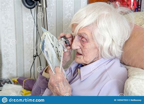 Visually Impaired Elderly Woman Reading With Magnifying
