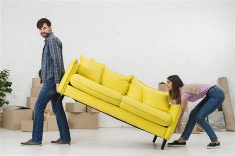 couple essayant de placer le canapé jaune dans leur nouvelle maison télécharger des photos