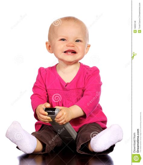 infant baby girl playing  tv remote stock photo image