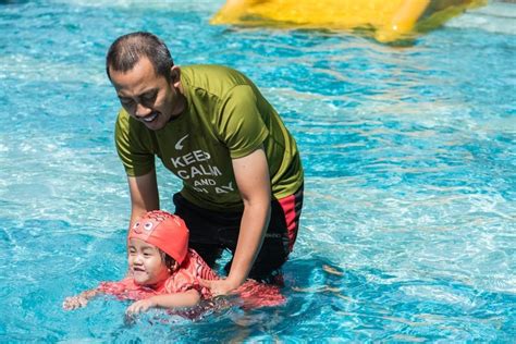 Little One S Enjoying Her Swimming Lesson With Daddy Help