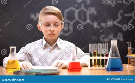 concentrated boy planning  conduct chemical experiment  colored