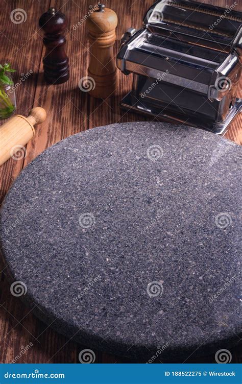 verticaal schot van een rond marmer oppervlak met deegrollen op een houten tafel stock