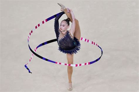 A Female Figure Is Performing With A Ribbon Around Her Neck And Hands