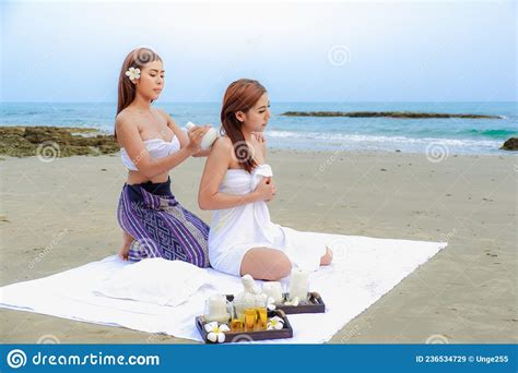 Two Asia Women Doing Spa Massage Together On The Tropical Beach Stock