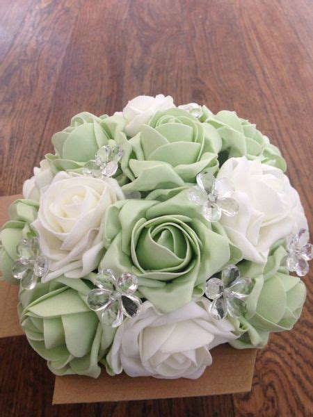 beautiful cluster of ivory and sage faux roses in mirror cube with