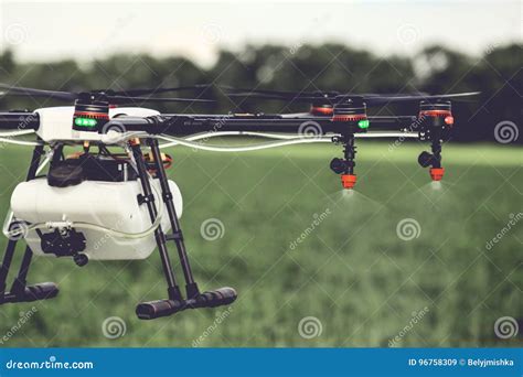 closeup view  agriculture drone spraying water fertilizer   green field stock image