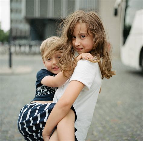 Big Sister Carrying Her Little Brother By Stocksy Contributor Jakob