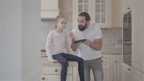 Emotional Father Scolding His Daughter For Something Holding A Plate In