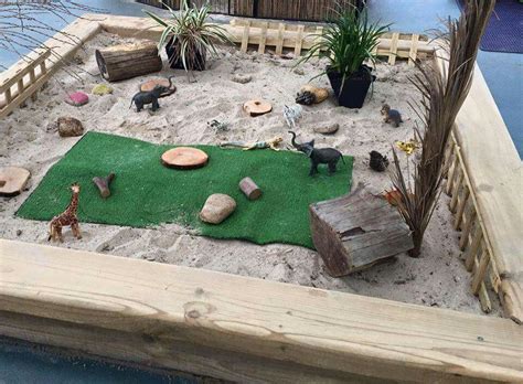 outdoor play area  fake animals  rocks   sand  top   wooden platform