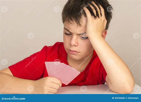 young boy playing cards stock photo image  hair concentration