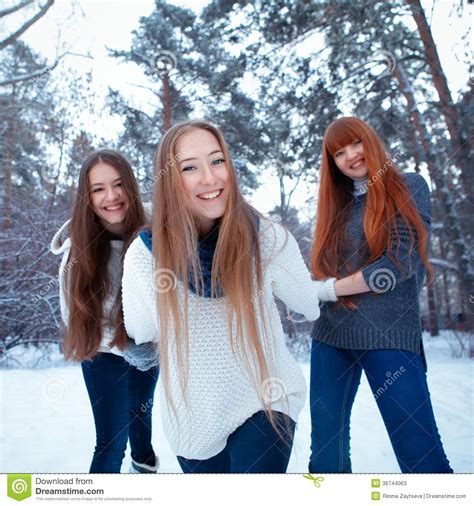 portrait of three beautiful girls in winter park stock