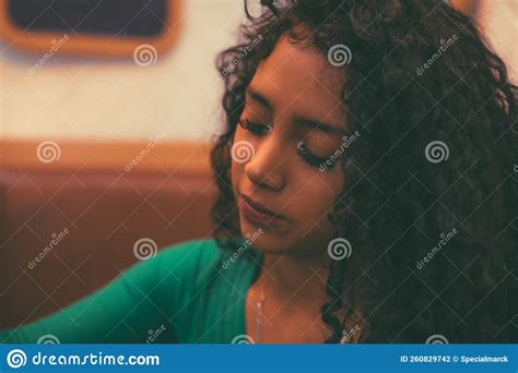 Curly Haired Brunette Girl Enjoys A Cup Of Coffee In A Cafe Besides