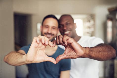 black and white couple gesturing heart with hands by flamingo images